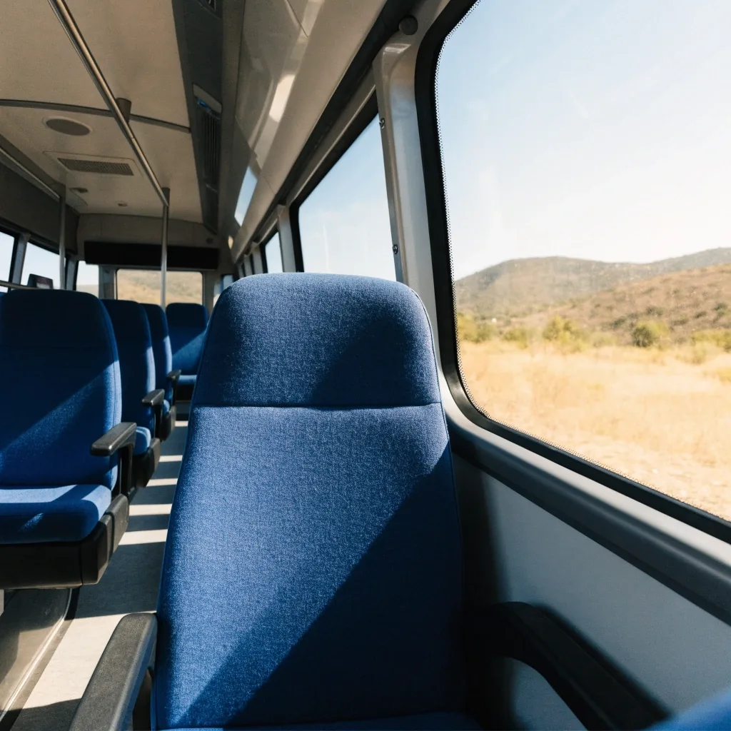 Andén de una estación de tren española con viajeros esperando junto a un tren regional